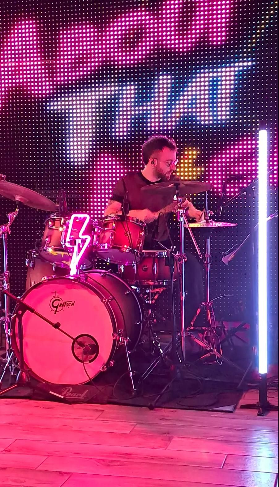 Eugenio alla batteria sotto luci al neon